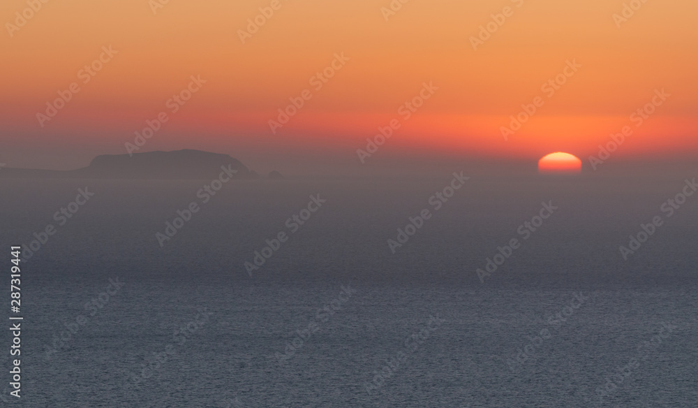 Blurred sunrise with thin mist in the Aegaean sea, Santorini island.