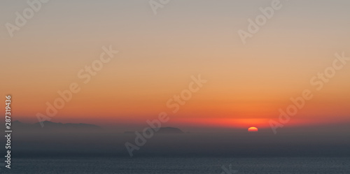 Blurred sunrise with thin mist in the Aegaean sea, Santorini island.