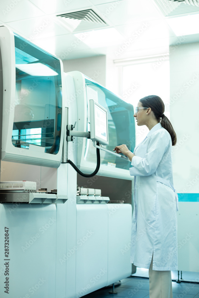 Concentrated young medical worker testing computer in lab