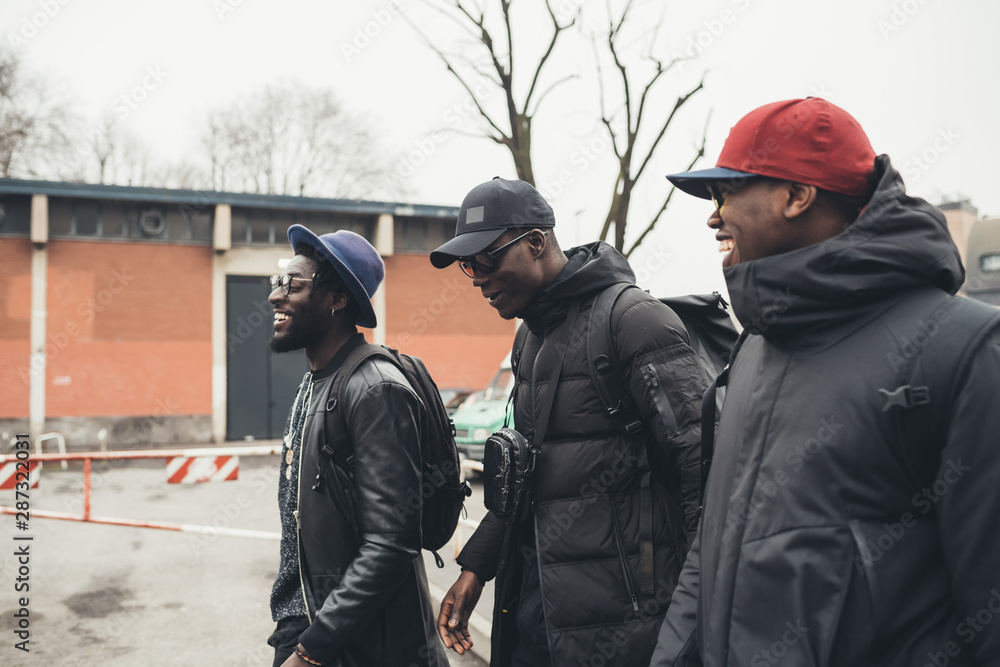 three young african men walking in the street together three young african men walking in the street together
