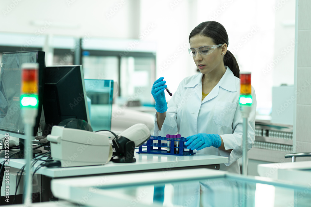 Charming brunette girl working with chemical reagents Charming brunette girl working with chemical reagents