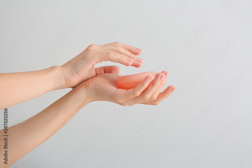 Female hands with soap bar on light background Female hands with soap bar on light background