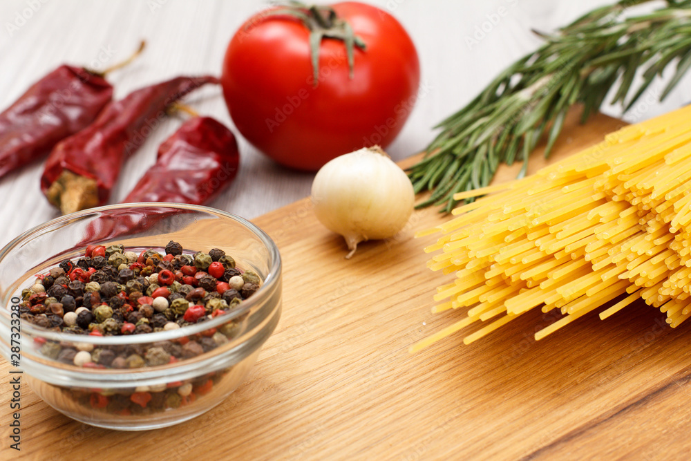Spaghetti and ingredients for cooking meat or fish on wooden cutting board. Spaghetti and ingredients for cooking meat or fish on wooden cutting board.