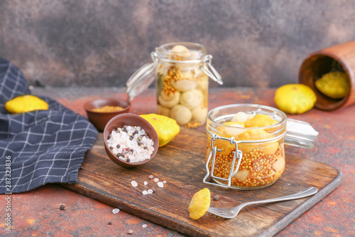 Jar with canned squashes on table