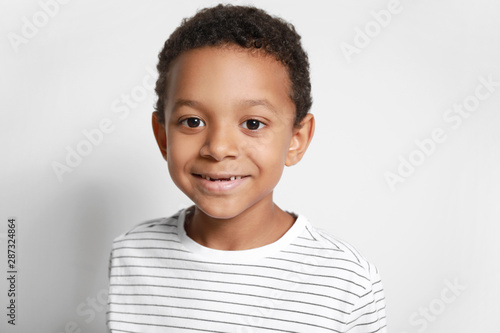Cute African-American boy on white background