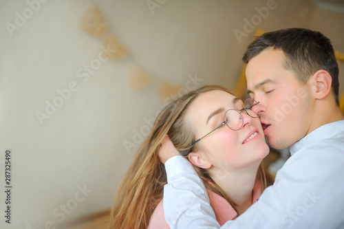 beautiful young couple kisses while standing in a room in the bedroom