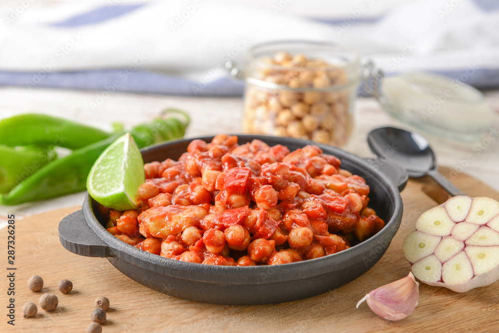 Frying pan with tasty chickpea in tomato sauce on table Frying pan with tasty chickpea in tomato sauce on table