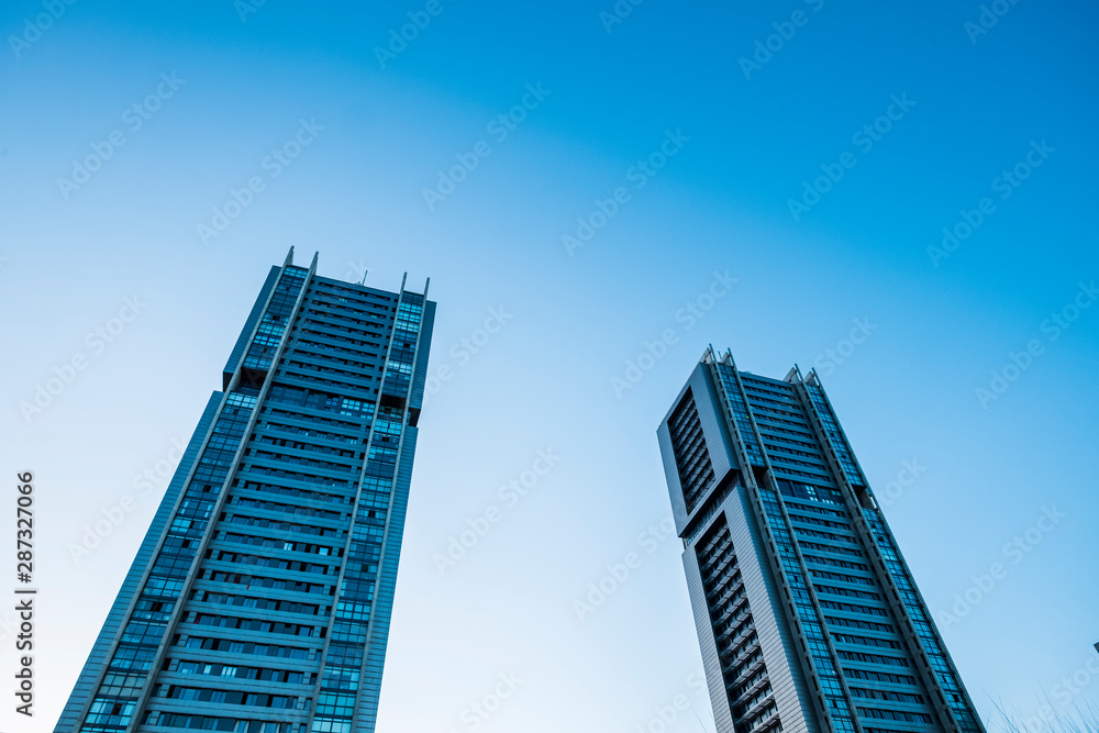 Blue cold tones colors of skyscrapers with sunlight - looking up perspective, city view of offices and financial district with bank and insurance people at work Blue cold tones colors of skyscrapers with sunlight - looking up perspective, city view of offices and financial district with bank and insurance people at work