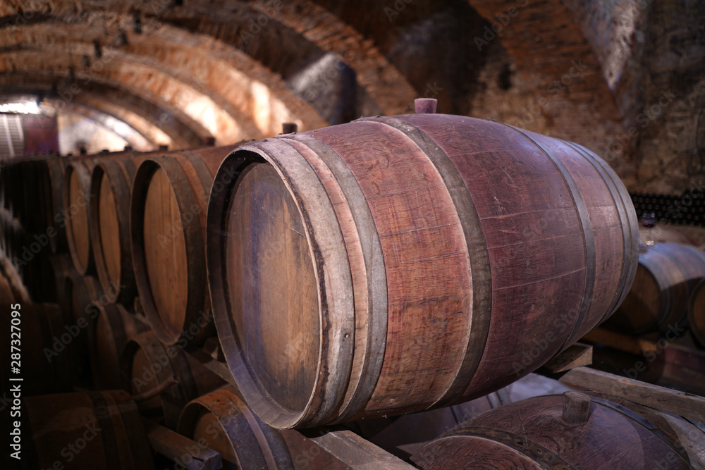 An old wine barrel in an ancient cellar. tasty and expensive wine