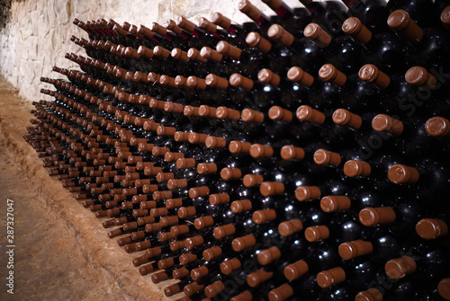 Expensive red wine bottles in an old wine cellar © spoilergen