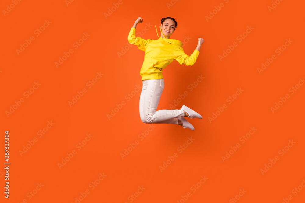 Full body photo of lovely teen raising fists smiling isolated over orange background - obrazy, fototapety, plakaty 
