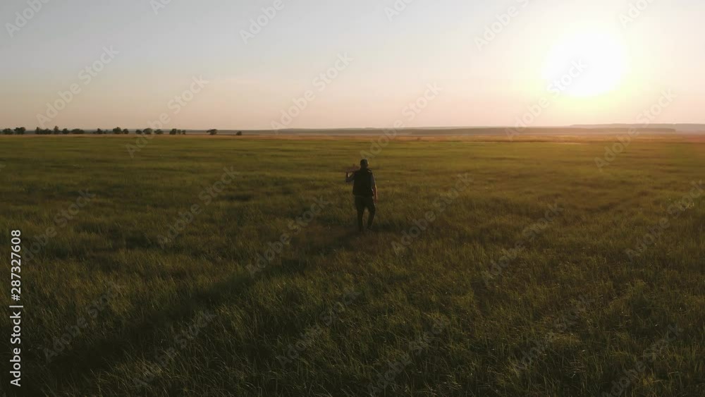 Silhouette young farmer going on the field at sunset with wooden box with fresh vegetables. Healthy eating, autumn harvest, farming concept. Silhouette young farmer going on the field at sunset with wooden box with fresh vegetables. Healthy eating, autumn harvest, farming concept.