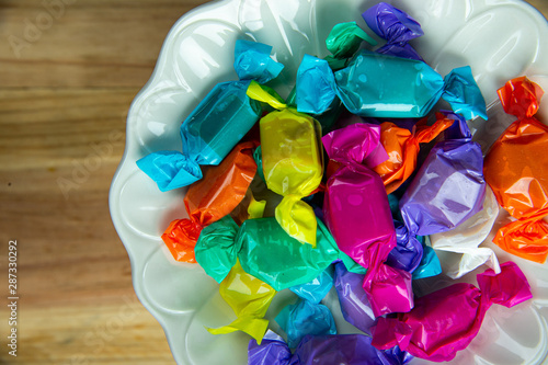Konstfotografi Top view beautiful colorful wrapped candies on white dish.