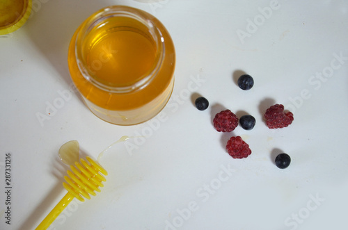 Healthy breakfast ingredients. fresh fruit, berries mint, a jar of honey with a spoon for honey on a white background. Top view, copy space