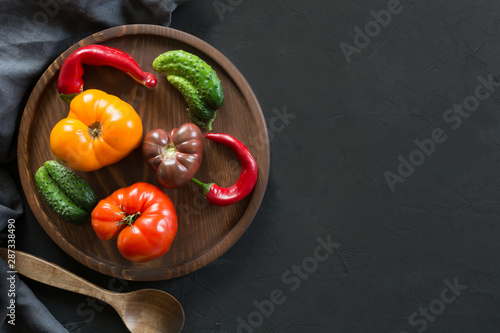Ugly organic colorful tomato, pepper, cucumber on black. Concept organic vegetables.