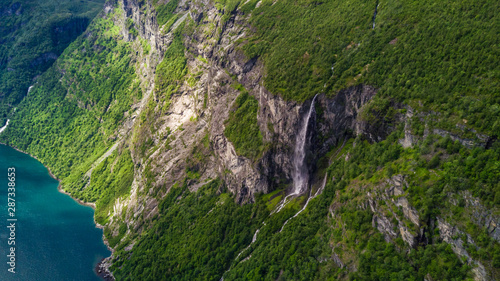 Aerial view of Sunnylvsfjorden fjord canyon  Geiranger village location  western Norway. Aerial evening view of famous Seven Sisters waterfalls. Beauty of nature concept background.
