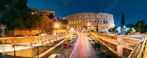 Rome, Italy. Colosseum Also Known As Flavian Amphitheatre. Traffic In Rome Near Famous World Landmark In Evening Time.
