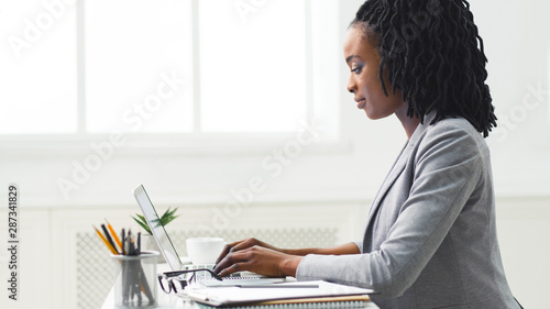 Young Afro Woman Working On Laptop Computer At Workplace