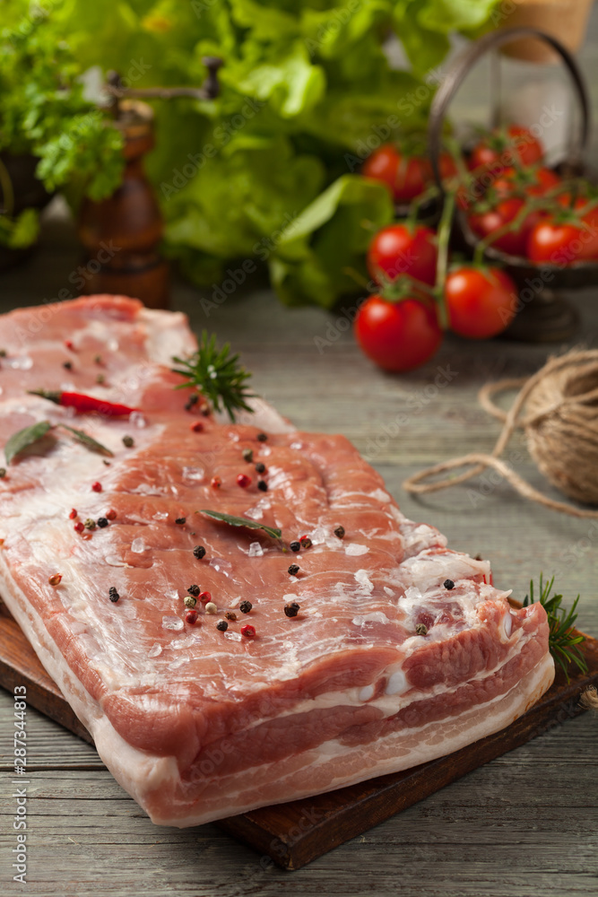 Raw bacon in whole on wooden background. Raw bacon in whole on wooden background.