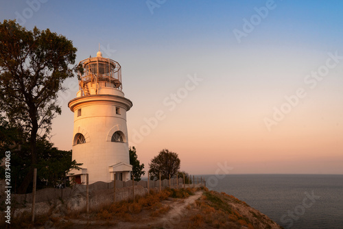 White sea lighthouse in Feodosia, Crimea on the Black Sea at sunset