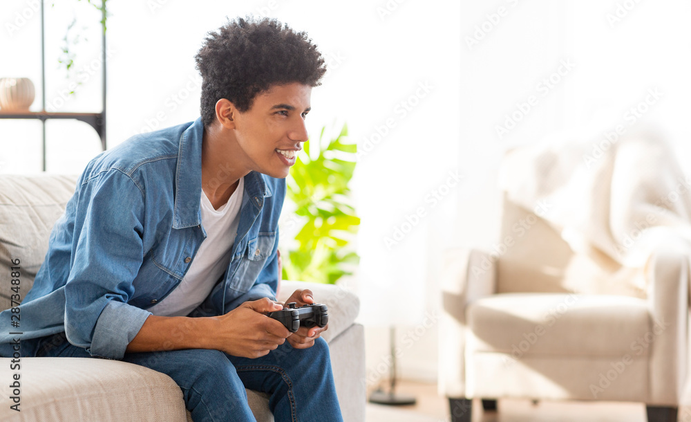 Happy african american guy playing video games at home Happy african american guy playing video games at home
