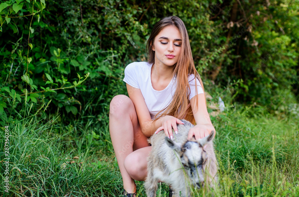 Woman play cute goat. United with nature. Animals law. Girl and goat green grass. Farm and farming concept. Village animals. Protect animals. Veterinarian occupation. Treating animals at farm Woman play cute goat. United with nature. Animals law. Girl and goat green grass. Farm and farming concept. Village animals. Protect animals. Veterinarian occupation. Treating animals at farm
