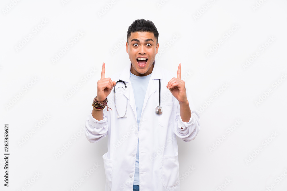 Young doctor man over isolated white wall pointing up a great idea Young doctor man over isolated white wall pointing up a great idea