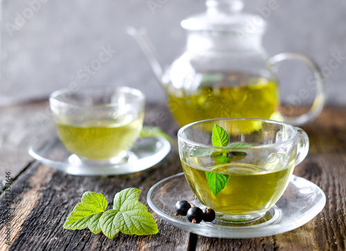  Green herbal tea with a berries in glass cup on wooden table background