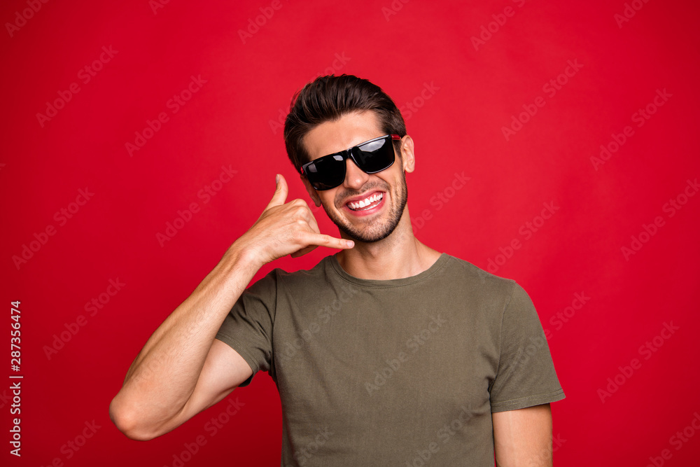 Amazing guy speaking over imaginary telephone with clients wearing casual grey t-shirt isolated on red background Amazing guy speaking over imaginary telephone with clients wearing casual grey t-shirt isolated on red background