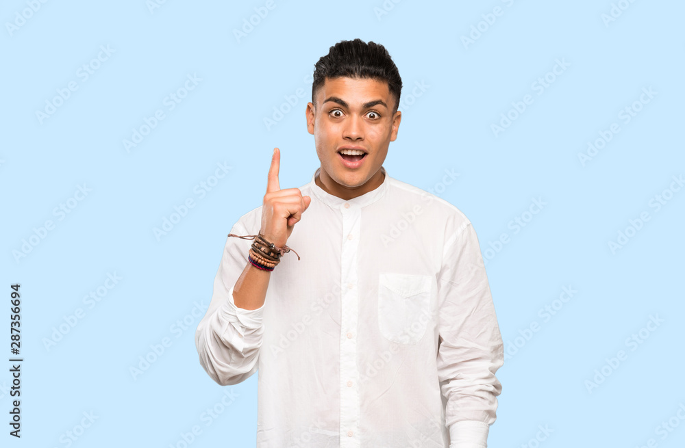Young man thinking an idea pointing the finger up on colorful background Young man thinking an idea pointing the finger up on colorful background