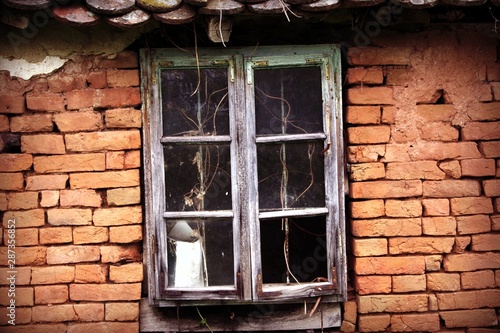 old vintage window on village bricks hut photo