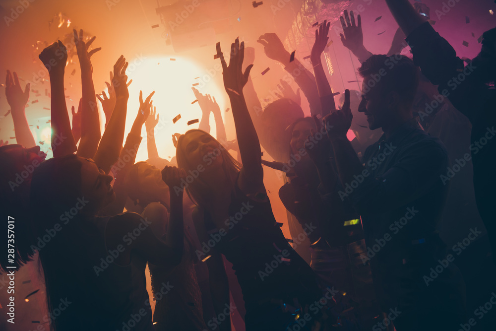 Photo of many party people buddies dancing yellow lights confetti flying everywhere nightclub event hands raised up wear shiny clothes