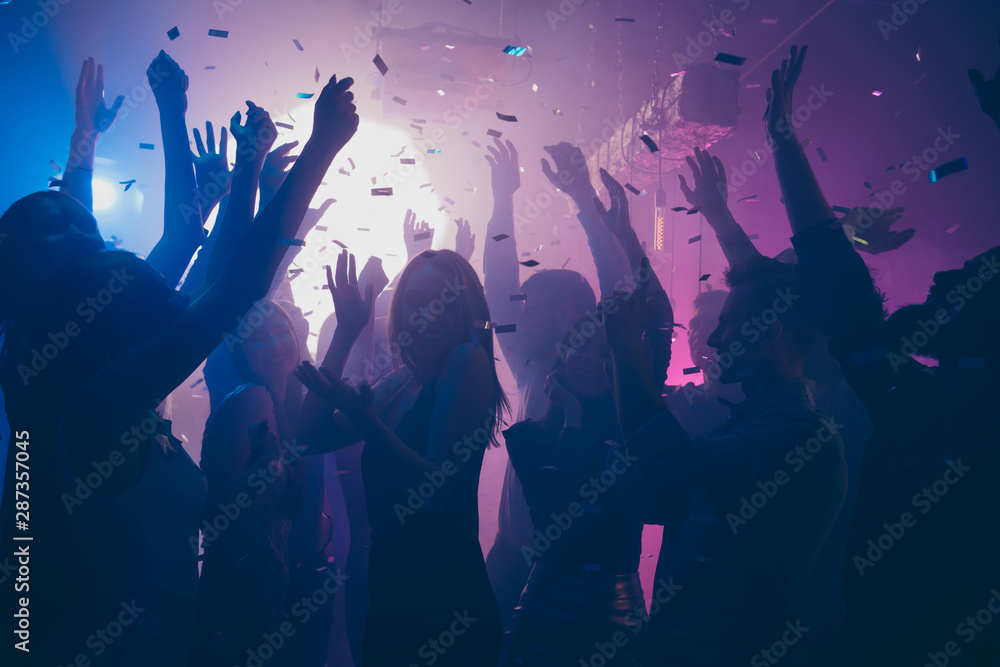 Close up photo of many party people dancing purple lights confetti ...