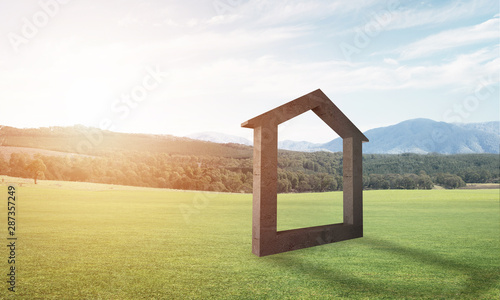 Conceptual background image of concrete home sign on green grass