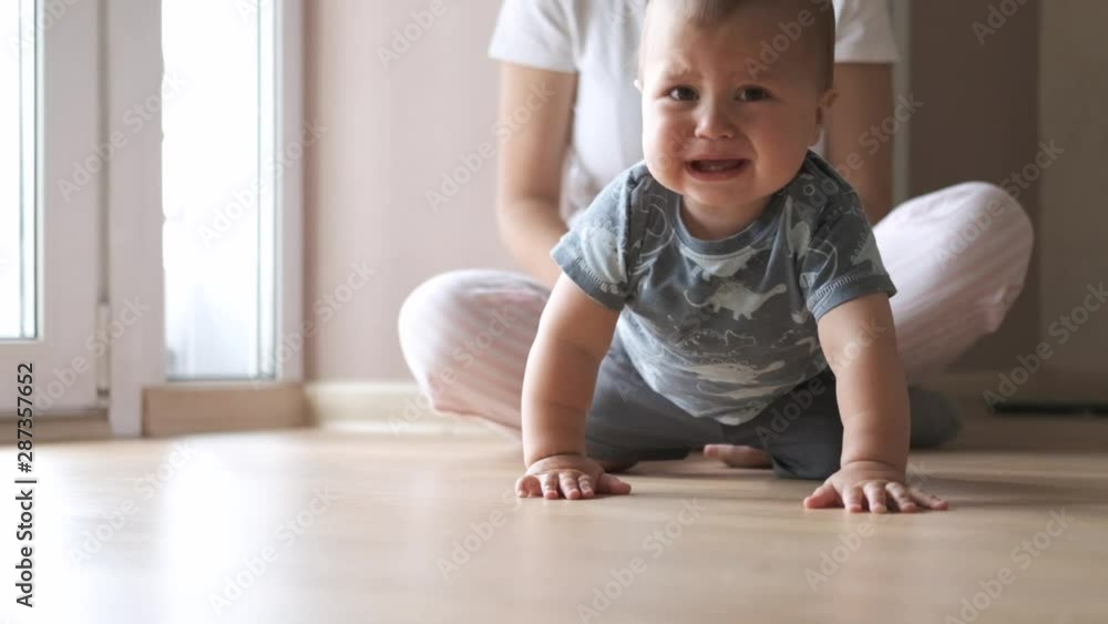 One year old baby boy cries, close-up. Babyboy crying at the floor One year old baby boy cries, close-up. Babyboy crying at the floor