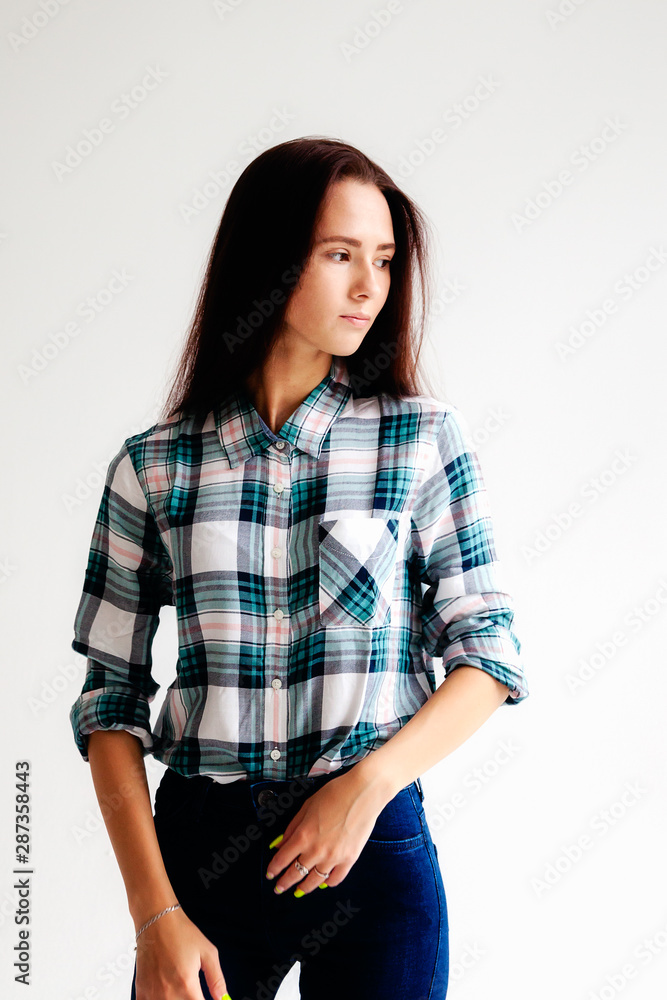 Girl in plaid shirt and jeans is on white background Girl in plaid shirt and jeans is on white background