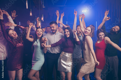 Portrait of charming pretty nice people person youth laugh fog smoke loud music noise place motion dynamic scream raise hand arms laughter indoors discotheque formal wear formalwear
