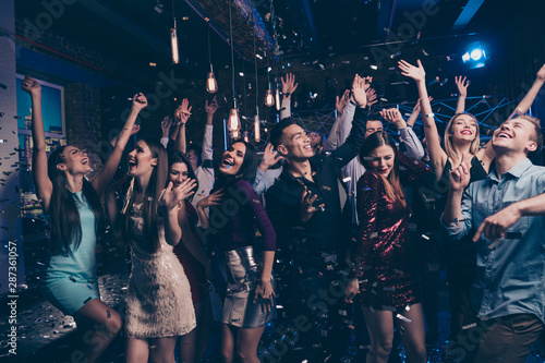 Portrait of attractive fellow buddies fellowship move motion laugh laughter dressed formal wear dress suit raise hands arms discotheque scream loud place