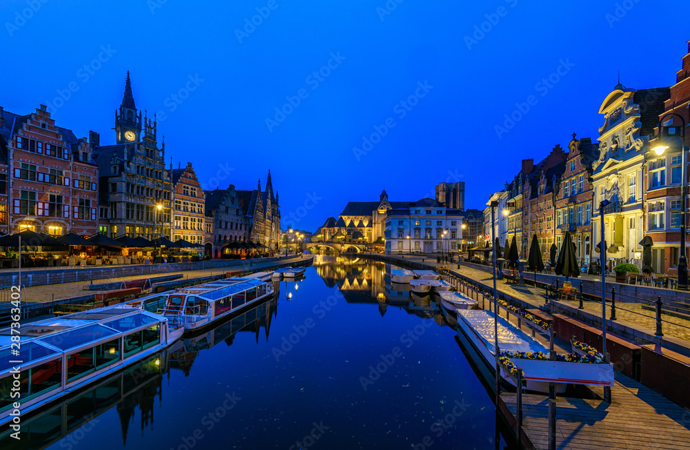 View of Graslei, Korenlei quays and Leie river in the historic city center in Ghent (Gent), Belgium. Architecture and landmark of Ghent. Night cityscape of Ghent.