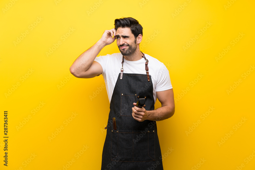 Young hairdresser man over isolated yellow background having doubts and with confuse face expression Young hairdresser man over isolated yellow background having doubts and with confuse face expression