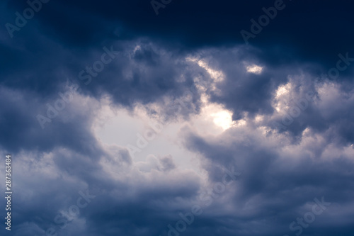 Blue hour sky clouds background. Beautiful landscape with stormy clouds and purple sun on sky