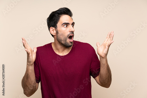 Handsome young man over isolated background with surprise facial expression