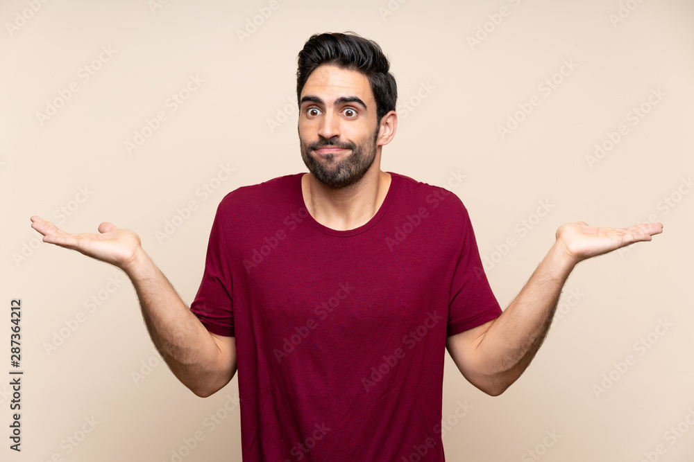 Handsome young man over isolated background having doubts with confuse face expression Handsome young man over isolated background having doubts with confuse face expression