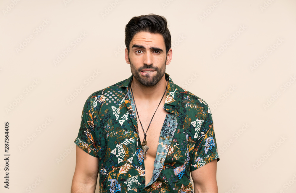 Obraz premium Handsome man in summer shirt over isolated background having doubts and with confuse face expression