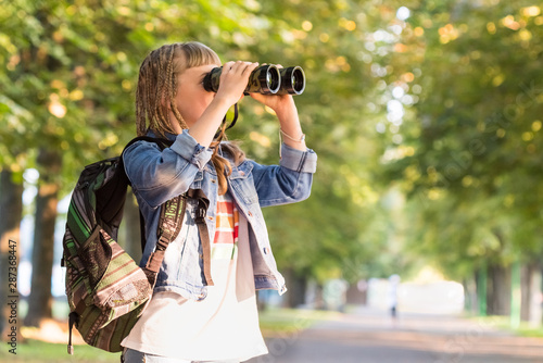 Teenage girl with binoculars in a park