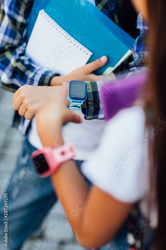 Close up view of two child with smartwatch. Little boy and girl showing hands with smartwatch and colourful wristbands.