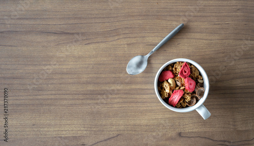 homemade granola with milk for breakfast on wooden table. top view