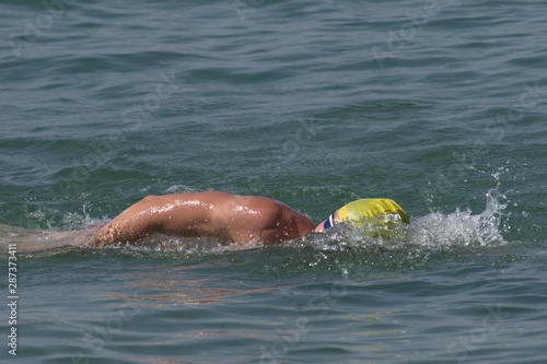 Person swimming freestyle in the see in marathon competition