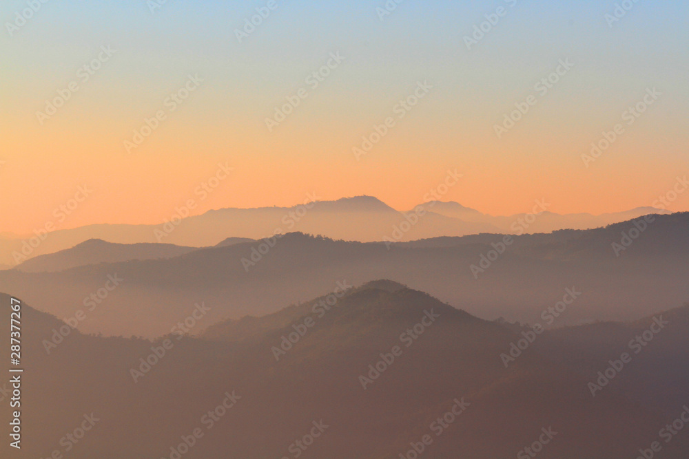 Obraz premium Beautiful Sunset and sunrise on sky and golden twilight time with mist and fog in valley of mountain layer