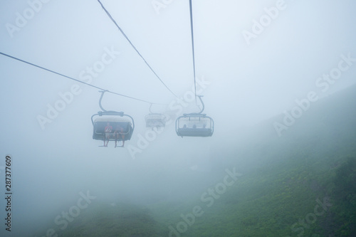 Tourists climb the mountains through dense clouds in the cabins of the cable car in the vicinity of the city of Sochi.